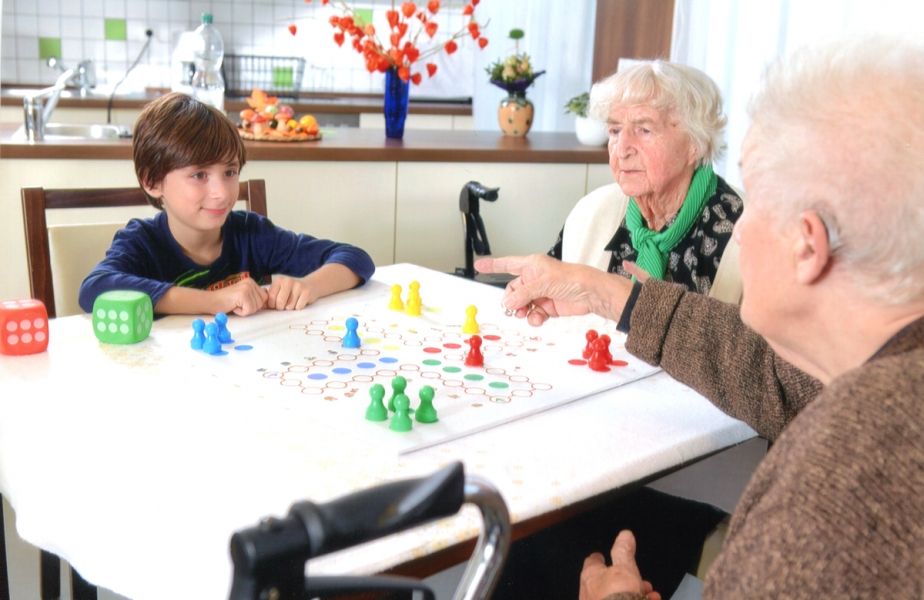 Kind spielt mit Senioren Brettspiel